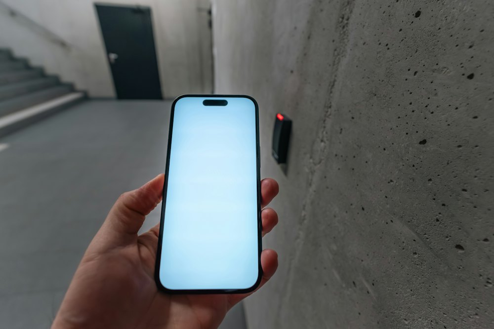 A phone held up to a tag fixed on a wall