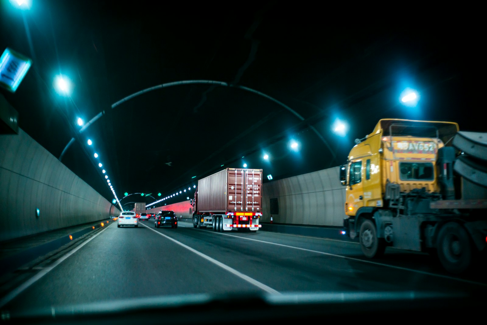 A freight truck driving through a tunnel at night